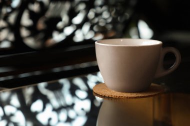 Cafe 'de kapaklı bardak altlığı ve siyah masa, yakın plan. Metin için boşluk