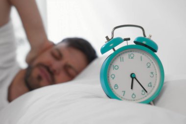 Uykulu adam sabah evde uyanıp çalar saate odaklanıyor. Metin için boşluk