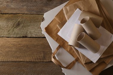 Tahta masanın üzerinde düz bir şekilde duran farklı atık kağıtları. Metin için boşluk