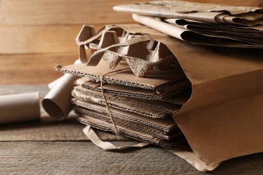 Ahşap masada farklı atık kağıtlar, yakın plan.