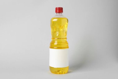 Açık gri arka planda bir şişe yemek yağı