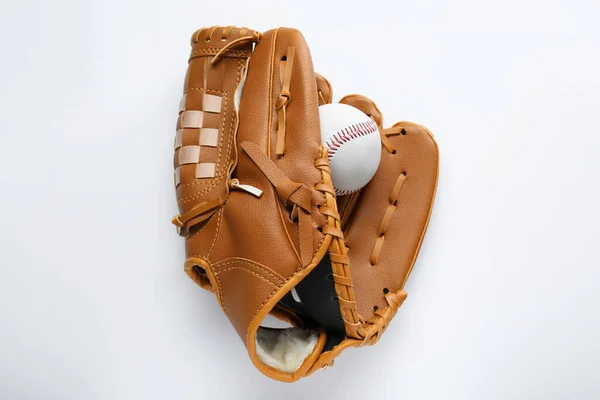 Catcher\'s mitt and baseball ball on white background, top view. Sports game