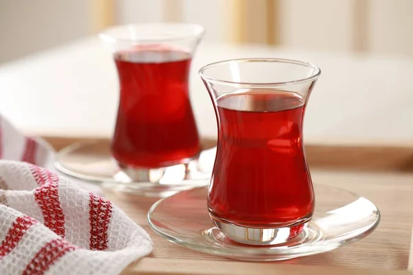 Glasses of traditional Turkish tea on wooden tray, closeup