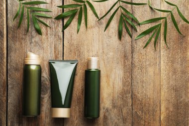 Düz kompozisyon ve kozmetik ürünler ahşap masanın üzerinde duruyordu. Metin için boşluk