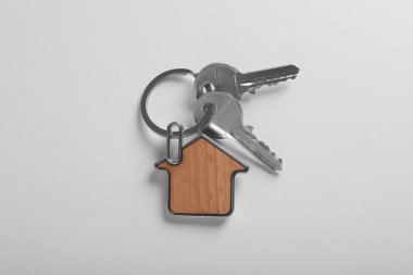 Beyaz arka planda ev şeklinde incik boncuklu anahtarlar, üst manzara. Emlakçılık hizmetleri