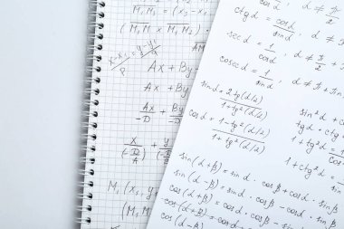 Beyaz masa üzerinde farklı matematiksel formüllere sahip kağıt sayfaları, üst görünüm