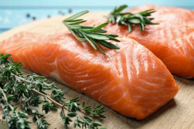 Taze çiğ somon ve ahşap tahtada terbiye edilecek malzemeler, yakın plan.