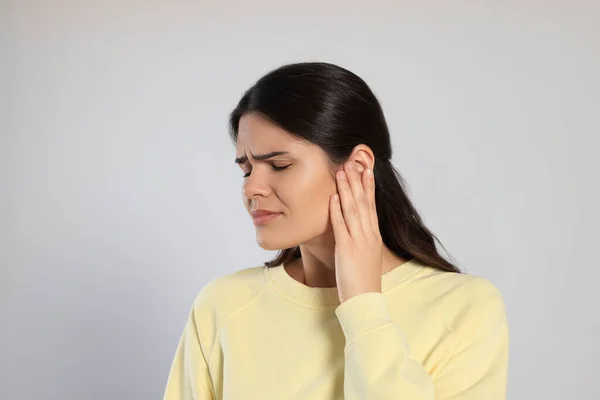 Young Woman Suffering Ear Pain Light Grey Background — Stock Photo, Image