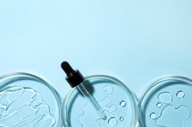 Açık mavi arka planda petri kabı ve pipet, düz. Metin için boşluk