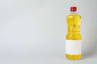 Açık gri arka planda bir şişe yemek yağı. Metin için boşluk