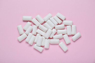 Soluk pembe arka planda leziz, beyaz sakız çiğneme.