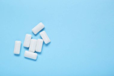 Açık mavi arka planda dişeti çiğneyen lezzetli, düz bir zemin. Metin için boşluk