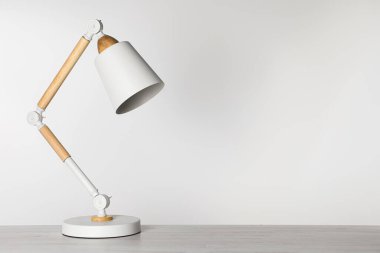 Beyaz ahşap masa üzerinde modern masa lambası, metin için alan