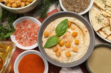 Lezzetli kremalı humus, nohut ve ahşap masa üzerinde farklı malzemeler, düz yatıyordu.