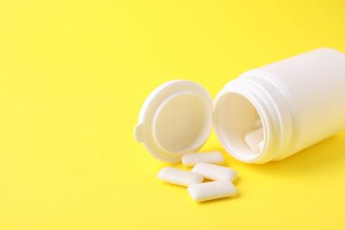 Sarı arka planda sakız çiğneyen kavanoz. Metin için boşluk