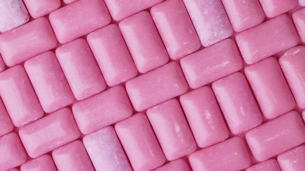 Many pink chewing gums as background, top view
