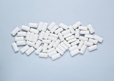 Açık gri arkaplanda beyaz sakız çiğniyor, düz yatıyordu.