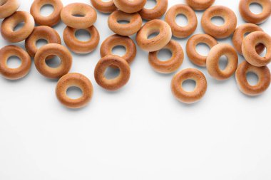 Beyaz arka planda birçok lezzetli kuru simit (sushki), düz yatıyordu. Metin için boşluk