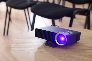 Modern video projektörü konferans odasındaki masada.