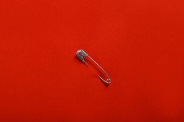 Kırmızı kağıda iliştirilmiş güvenlik iğnesi, üst görünüm