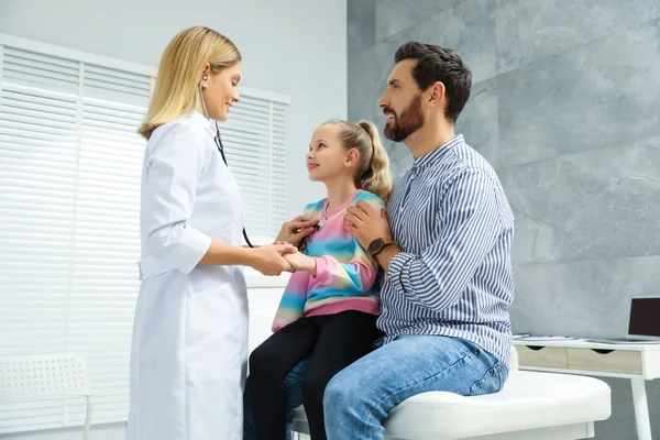 Father and daughter having appointment with doctor in clinic