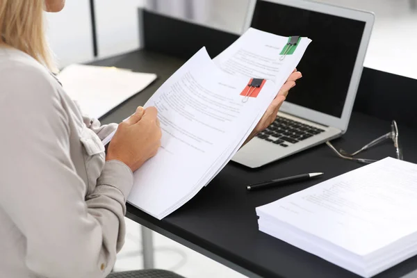 Businesswoman working with documents at table in office, closeup