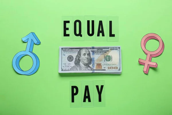 Equal pay. Gender symbols with stack of dollar banknotes on green background, flat lay