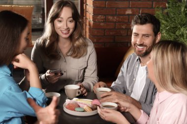 Kahveli arkadaşlar birlikte kafede vakit geçiriyorlar.