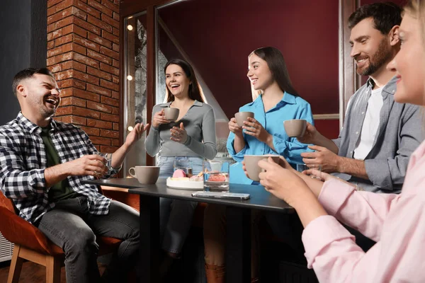 Kahveli arkadaşlar birlikte kafede vakit geçiriyorlar.