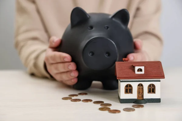 Man Holding Piggy Bank House Model Coins Wooden Table Closeup — Foto de Stock