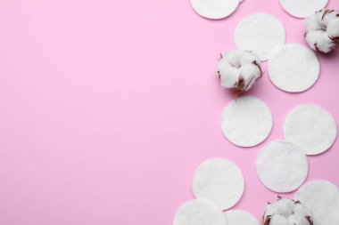 Yumuşak, temiz pamuk pedleri ve pembe arka planda çiçekler. Metin için boşluk