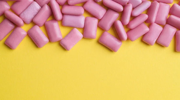 Sweet chewing gums on yellow background, flat lay. Space for text