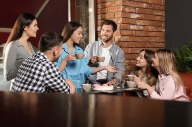 Kahveli arkadaşlar birlikte kafede vakit geçiriyorlar.