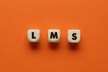Learning management system. Wooden cubes with abbreviation LMS on orange background, top view