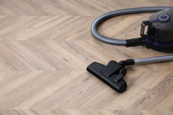 Modern vacuum cleaner on floor. Space for text