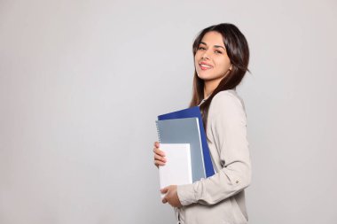 Açık gri arka plan kitapları olan mutlu genç öğretmen. Metin için boşluk