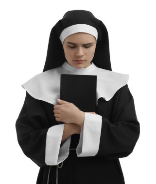 Young nun holding Bible on white background