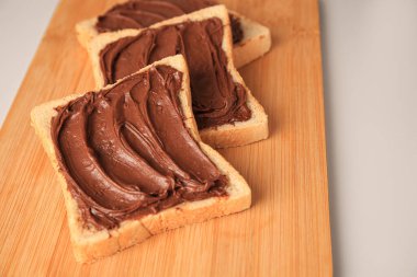 Tasty toasts with chocolate paste on beige background, closeup. Space for text