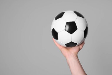 Man with soccer ball on light grey background, closeup. Space for text
