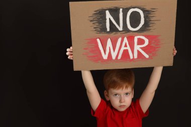 Boy holding poster No War against black background, space for text