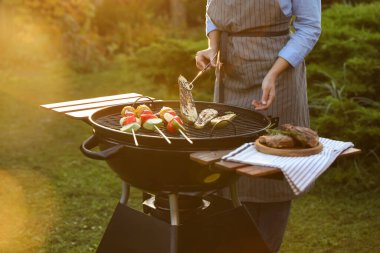 Barbekü ızgarasında sebze pişiren kadın, yakın plan.