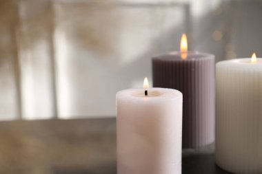 Kapalı alandaki gri masada farklı yanan mumlar. Metin için boşluk