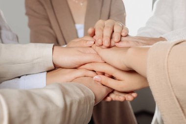 Group of people holding hands together indoors, closeup. Unity concept