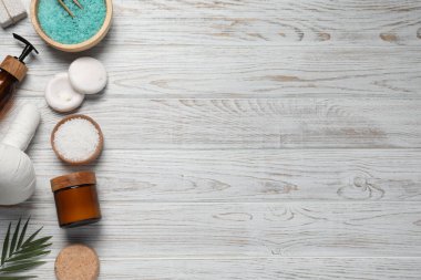Flat lay composition of herbal bag and spa products on white wooden table, space for text