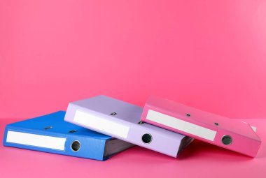 Office folders on pink background, space for text
