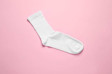 One white sock on pink background, top view