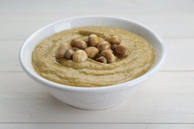 Delicious mushroom cream soup on white wooden table
