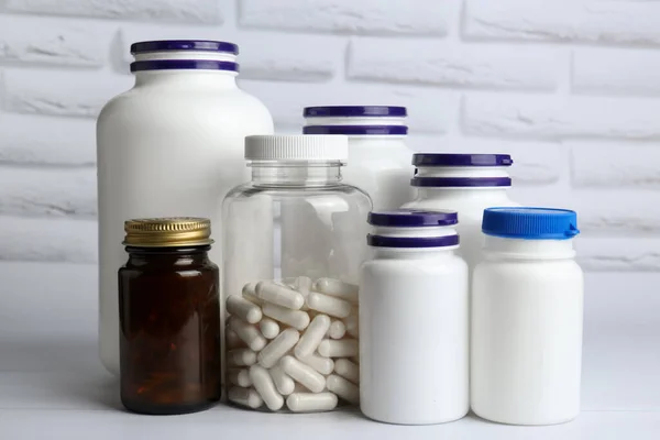 Different medical bottles on white wooden table