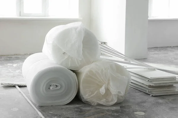 Polyethylene foam rolls on floor near windows in room