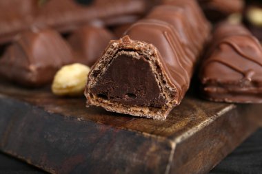 Sweet tasty chocolate bars on wooden board, closeup